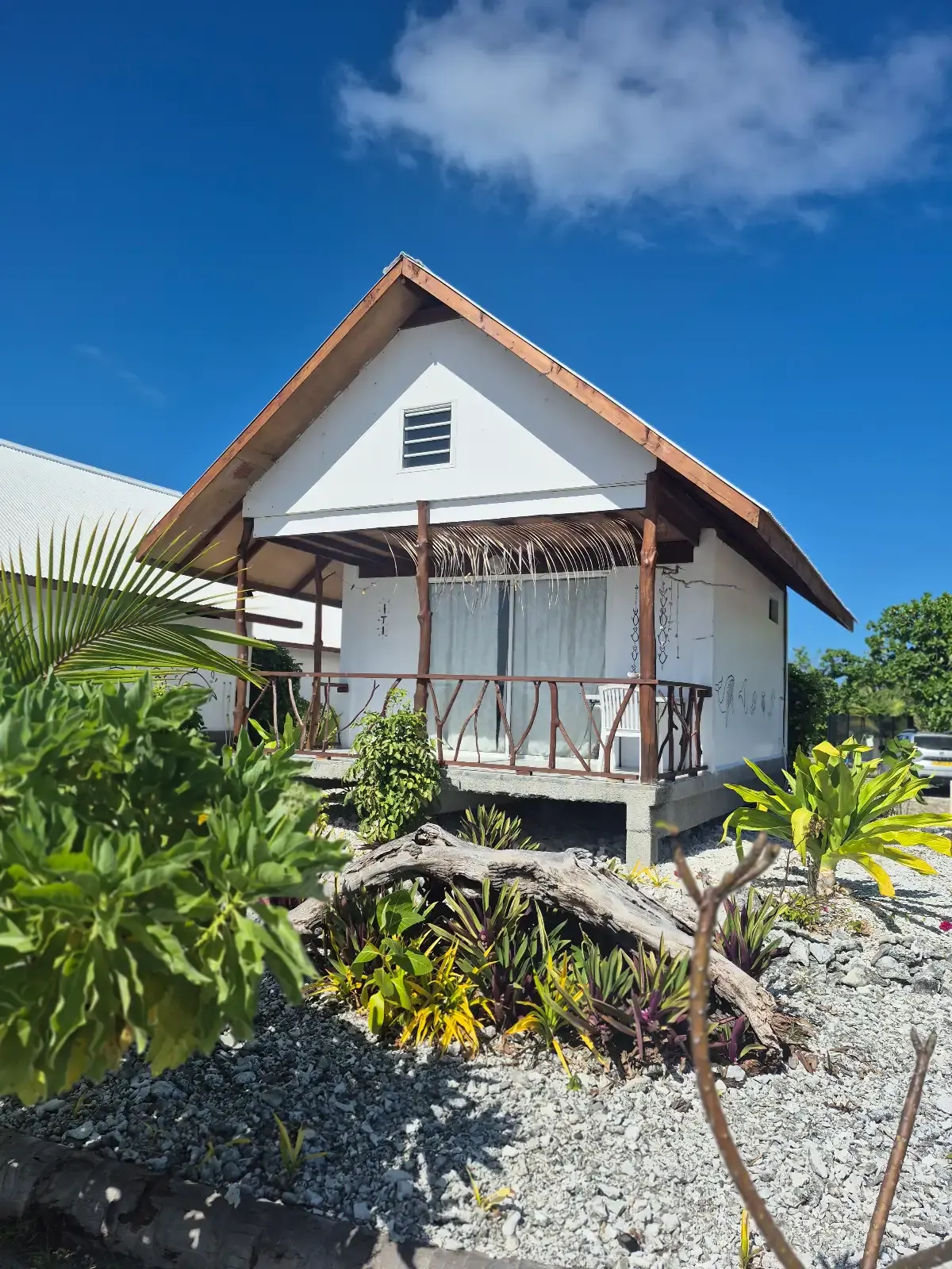 Bungalow blanc du Vaimoe Lodge sous le ciel bleu de Rangiroa